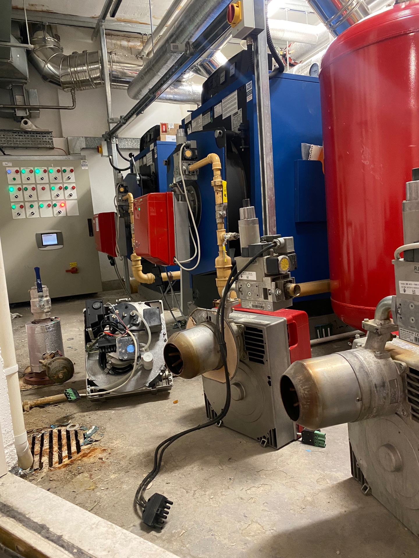 Commercial boiler room equipment showing blue industrial heating system requiring professional maintenance